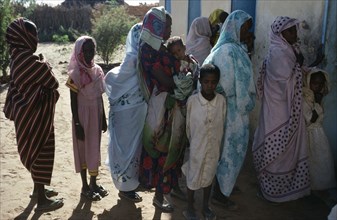SUDAN, Asernei, Chadian refugee women and children forming queue outside Islamic African Relief