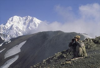 PAKISTAN, North West Frontier Province, Chitral, "Hill tribe hunter, with Tirich Mir in the