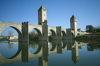 FRANCE, Midi Pyreees Lot , Cahors, Pont Valentre. Bridge with two towers and it’s reflection in the