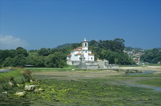 SPAIN, Asturias, Barro, Traditional white church with bell tower and graveyard. Building alone in a