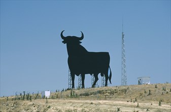 SPAIN, Andalucia, Cadiz, Large silhouette statue of a bull in a field.