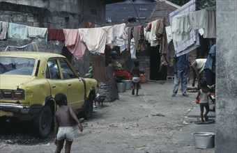 CONGO, Kinshasa, Housing for extended family with parked car and hanging washing.