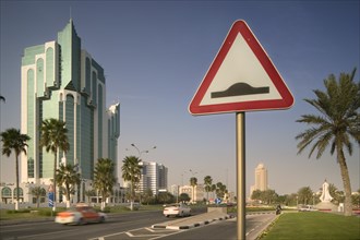 QATAR, Doha, "A road sign on The Corniche, palm trees either side of the road."