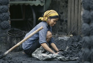 VIETNAM, Work, Woman making cakes of coal dust used as to fire kilns.