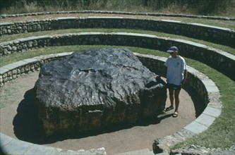NAMIBIA, Hoba Meteorite, "Largest in the World, woman standing next to it."