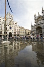ITALY, Veneto, Venice, Aqua Alta High Water flooding in St Marks Square with tourists on elevated