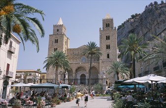 ITALY, Sicily, Palermo, Cefalu. Pathway towards II Duomo Norman Cathedral between cafes with people