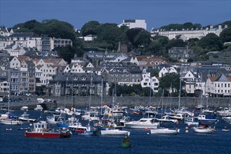 UNITED KINGDOM, Channel Islands, Guernsey, St Peter Port. View from across sea towards marina and