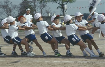 JAPAN, Honshu, Chiba, Tako.  Eight year old boys in tug of war during Undoukai sports festival.