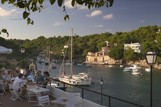SPAIN, Balearic Islands, Mallorca, "Cala Figuera, Tourists enjoying a drink at a cafe over looking