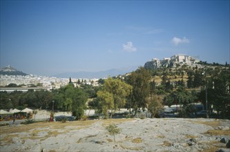 GREECE, Central, Athens, View of  Acropolis and Lykavitos behind a road with trees.