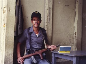 GUATEMALA, Antigua, An armed guard outside the entrance to a prison.