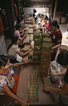 MYANMAR, Bago, Line of female workers inside cheroot factory.