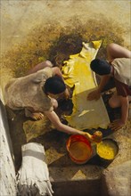 MOROCCO, Fes, Chouwara Tanneries.  Looking down on two men dyeing stretched and prepared hide
