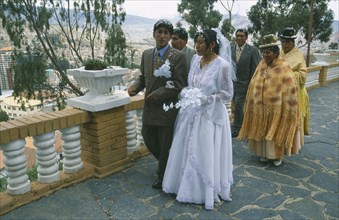 BOLIVIA, La Paz, Wedding in El Monticulo. Bride and Groom walking with guests behind.