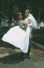 BOLIVIA, La Paz, Wedding in El Monticulo. Groom lifting up Bride.