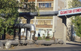 KAZAKHSTAN, Kyzlorda, Water heating pipes with apartment block behind.