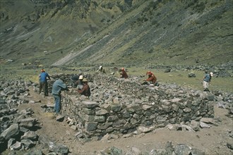PERU, Cusco, Cancha Cancha, Local Quechuan men building a house.