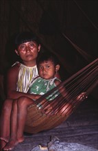 VENEZUELA, Orinoco Delta, Warao Indian woman with daughter in hammock.
