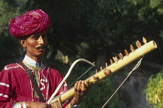 INDIA, Rajasthan, Musician with Tambora instrument.