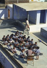 INDIA, Rajastan, Narlei, School children receiving their class on top of a roof.