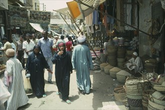 EGYPT, Aswan, Busy souk market scene with pulse vendor and crowds walking by.