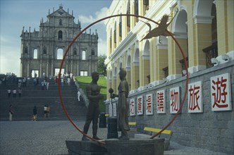 MACAU, , St Pauls Ruins with sculpture of a man and woman holding a flower standing in a red ring.