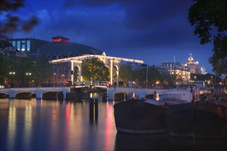 HOLLAND, North, Amsterdam, "Magere Brug, Skinny Bridge, at dusk with The Koninklijk Theater Carre