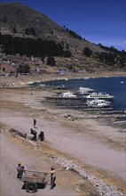 PERU, Puno, Lake Titicaca, Lake side scene with boats and people.