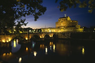 ITALY, Lazio, Rome, Ponte Sant’ Angelo and Castel Sant’ Angelo at night with lights reflected in