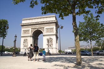 FRANCE, Ile de France, Paris, Tourist family standing in the shade of a tree in Place de Charles de