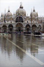 ITALY, Veneto, Venice, Aqua Alta High Water flooding in St Marks Square showing St Marks Basilica