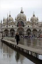 ITALY, Veneto, Venice, Aqua Alta High Water flooding in St Marks Square showing St Marks Basilica
