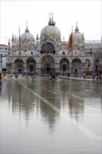 ITALY, Veneto, Venice, Aqua Alta High Water flooding in St Marks Square with St Marks Basilica at