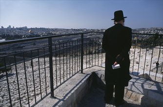 ISRAEL, Jerusalem, Elderly Ultra Orthodox Jewish man holding a bible in his hand surveying the