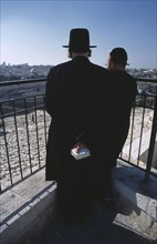 ISRAEL, Jerusalem, Two elderly Ultra Orthodox Jewish men one holding a bible in his hand surveying
