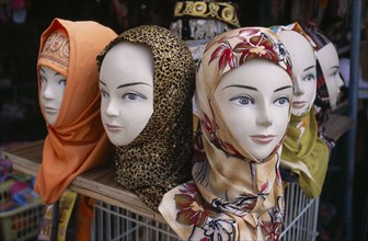 ISRAEL, Acre, Arabic mannequin heads displaying an array of different headscarves for sale on shop