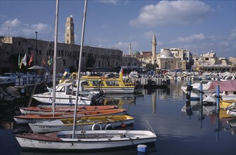 ISRAEL, Acre, "View across the harbour with moored boats towards Mosques, Minarets and an ancient