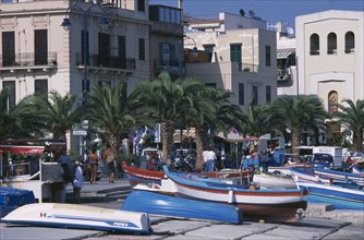 ITALY, Sicily, Palermo, Mondello. Fishing boats moored next to the promenade overlooked by