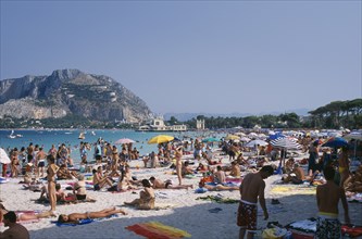 ITALY, Sicily, Palermo, Mondello Beach. View across busy sandy beach with sunbathers on sand