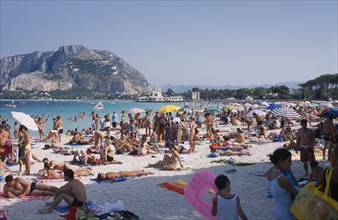 ITALY, Sicily, Palermo, Mondello Beach. View across busy sandy beach with sunbathers on sand