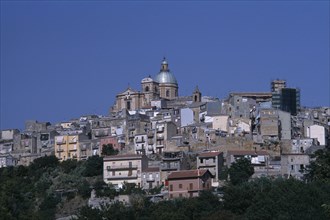 ITALY, Sicily, Enna, Piazza Armerina. Hilltop town buildings with a church dome at the top
