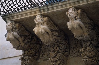 ITALY, Sicily, Noto, Via Nicolaci. Detail of sculpted female figures on ornate balconies