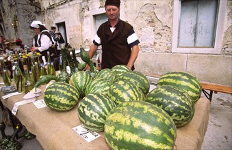 CROATIA, Istria, Buset, Man selling watermelons. The streets of old town Buzet are a riot of colour