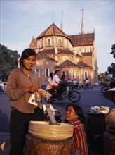 VIETNAM, South, Ho Chi Minh City, Female street hawkers selling snacks in front of Notre Dame