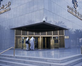 KUWAIT, Kuwait City, Exterior of Al-Ahli Bank of Kuwait with two men about to enter.