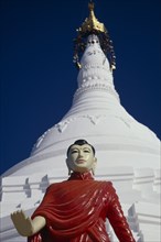 MYANMAR, Religion, Buddhism, White stupa at newly painted temple on road to Mandalay with standing