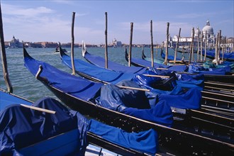 ITALY, Veneto, Venice, Line of gondolas moored at Piazza San Marco jetty with Santa Maria della