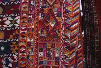 KUWAIT, Kuwait City, Detail of brightly coloured Bedouin textiles for sale at market.