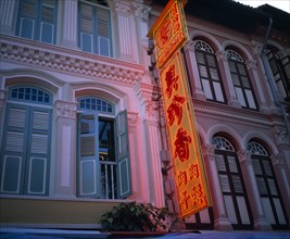 SINGAPORE, Chinatown, Renovated old colonial facades with orange neon sign in Chinese script.